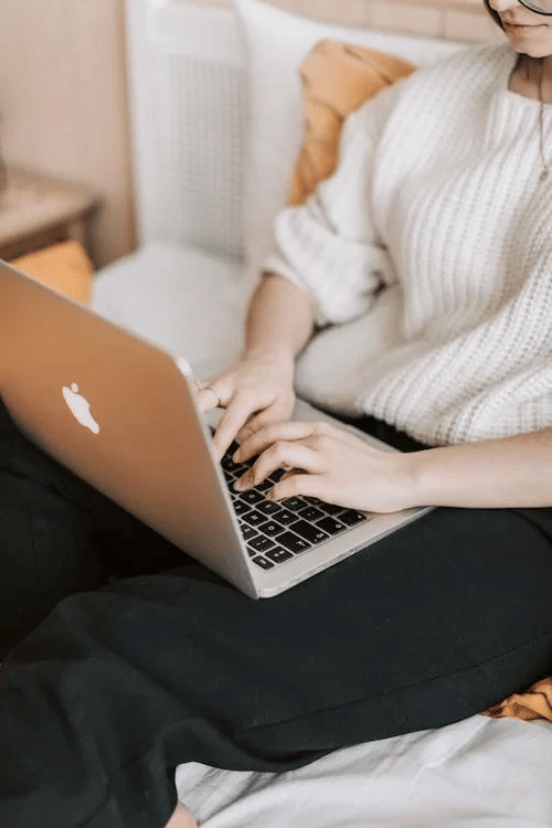 Person working on a laptop while seated comfortably indoors