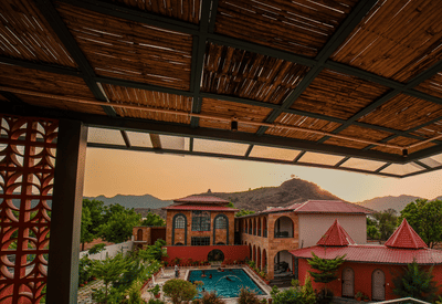 Balcony view of the pool and mountains at sunset at Nazaara Hills Retreat, Udaipur