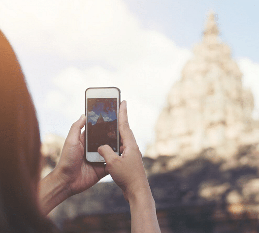 A person taking a photo of a temple with their smartphone. 