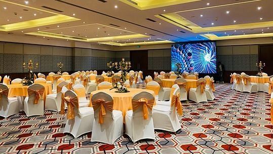 Banquet hall setup with round tables and white chair covers at Karma Chalets.