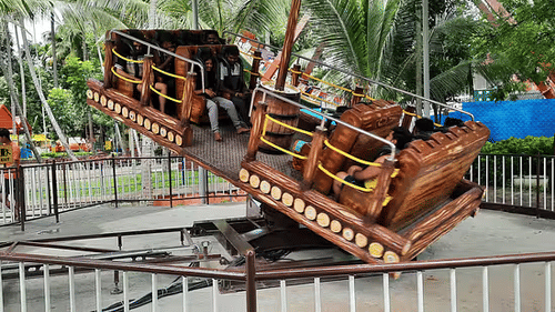 Pirate ship swinging ride at Black Thunder amusement park with lush palm trees in the background