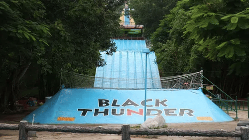 Water slide entrance at Black Thunder water park with a steep slope and scenic green surroundings