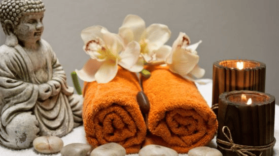 a small statue, towels and candles kept on a table in the spa at Abad Harmonia, Kovalam - The Best Ayurvedic Spa in Kovalam