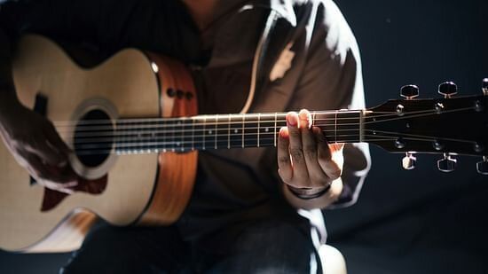 A musician playing acoustic guitar, reflecting the artistic ambiance.