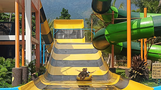 A colorful water slide structure at Black Thunder - Water Theme Park, with stairs leading up to the top and a slide curving down into a pool.