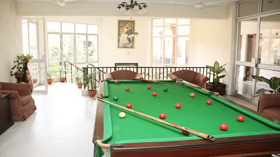 A billiards table with balls illuminated under bright lighting