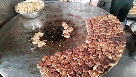 A pan of sliced meat and vegetables being cooked.