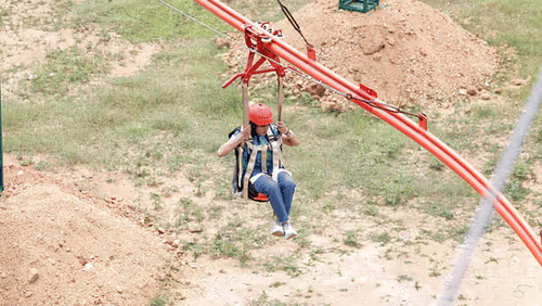 A Woman enjoying the Zipline Coaster ride with a safety helmet at Black Thunder, showcasing the park’s thrilling adventure experience.