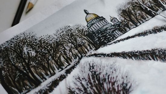 A winter landscape showing snow-covered mountains and trees,