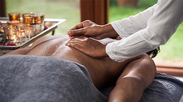 A person receiving a massage on their back, close-up shot, indoor setting - Shreyas Retreat
