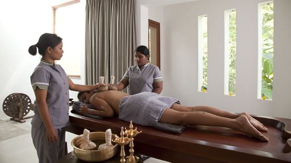 Two therapists performing a synchronized full-body Ayurvedic massage - Shreyas Retreat