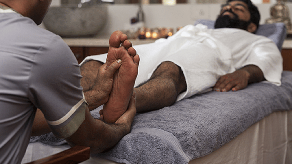 Person receiving a foot massage, close-up shot, spa treatment - Shreyas Retreat