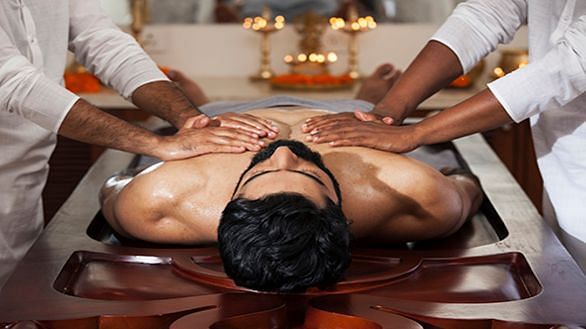 Two therapists performing a synchronized traditional full-body massage - Shreyas Retreat