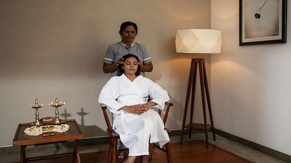 A client sitting comfortably while a therapist prepares for an Ayurvedic session - Shreyas Retreat
