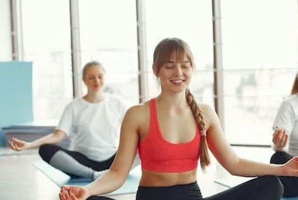Women performing yoga poses on mats in a serene studio setting.