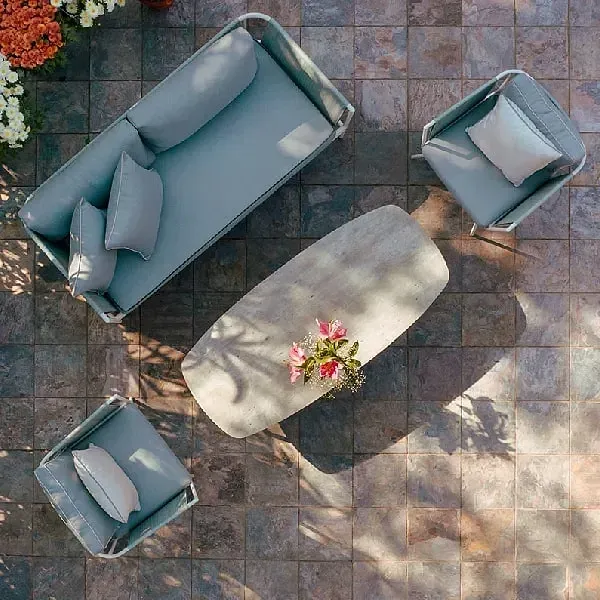 Overhead view of an outdoor seating area with a grey sofa, chairs, and a central table at Karma Chalets.