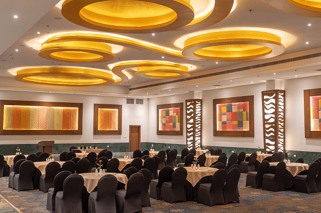 A banquet hall with tables and chairs set for an event. - Bamboo Saa Resort & Spa, Udaipur.