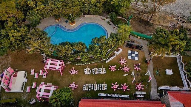 alt-text Overhead shot of a wedding venue with a pool and colorful decorations.