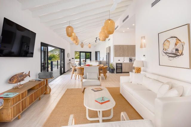 Modern open-concept living space with white interiors and natural wood accents at Tamarind Hills Resort and Villas, Antigua