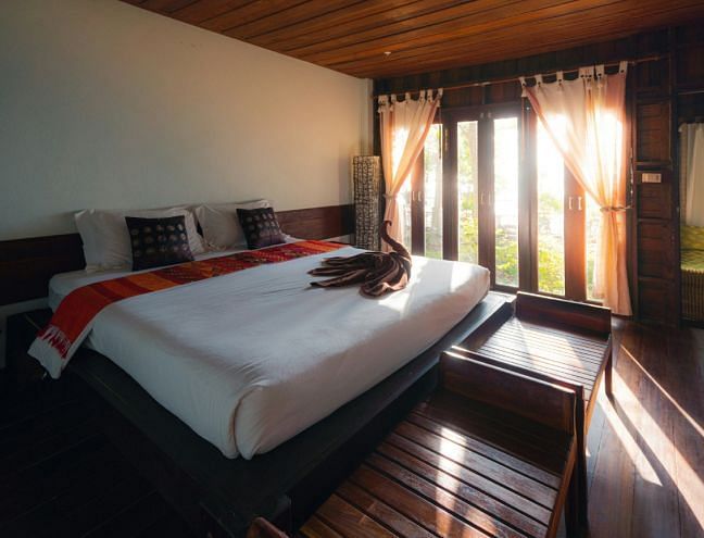 A hotel room with a double bed and large windows - Narrow Gauge Inn - A Serenite Hotel Near Fish Camp.