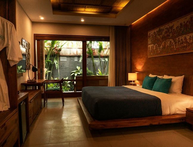 A hotel room with a double bed and large windows - Narrow Gauge Inn - A Serenite Hotel Near Fish Camp.