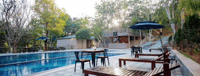 Image of a pool with lounge seats on the side at Essentia Luxury Resort and Spa, Udaipur