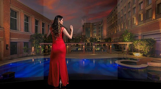 A woman looking at the swimming pool at Nirvana Luxury Hotel, Ludhiana during the evening
