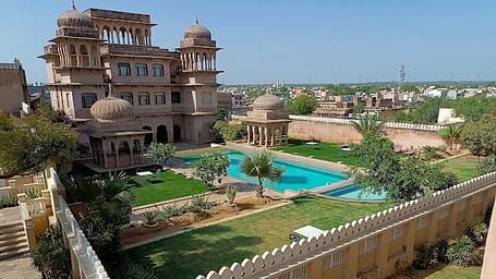 A facade image of Castle Mandawa with a swimming pool infront