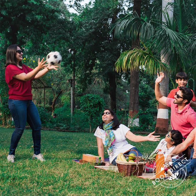 Family enjoying with a soccer ball midst a picnic