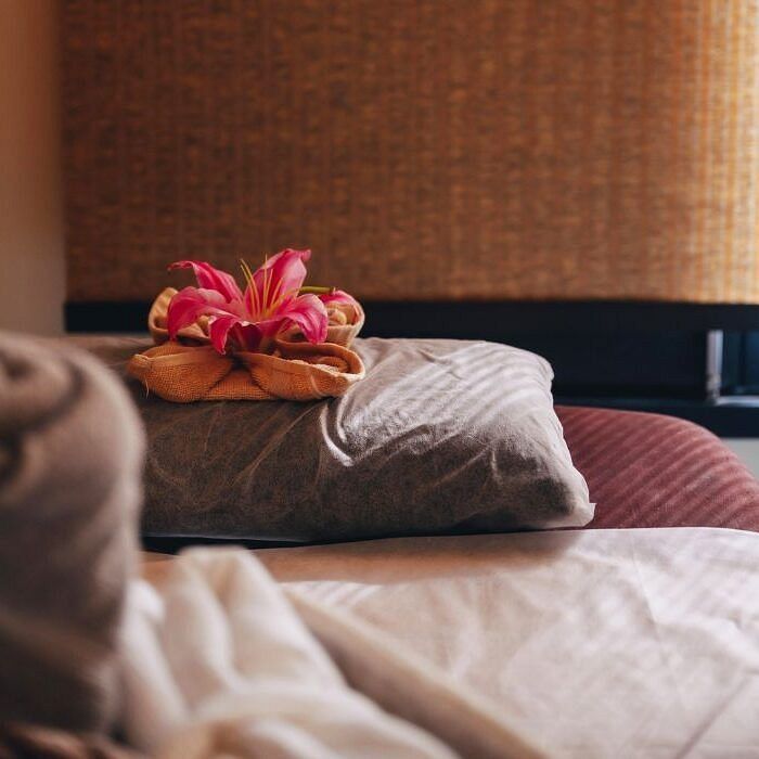 Bed with pillows and flower arrangement in a room at Karma Chalets.