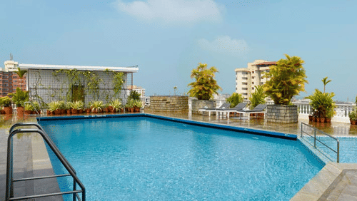 An overview of the Rooftop Swimming Pool at Abad Atrium, MG Road with trees in view.