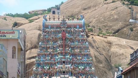 Facade shot of Tirupparamkunram Murugan Temple with rock mountain in the background.