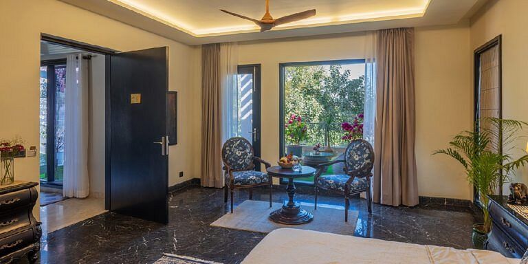 Room with marble flooring, seating area near glass doors, and indoor plants at Karma Chalets.