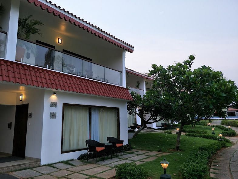Facade of a property surrounded by trees and grassland.
