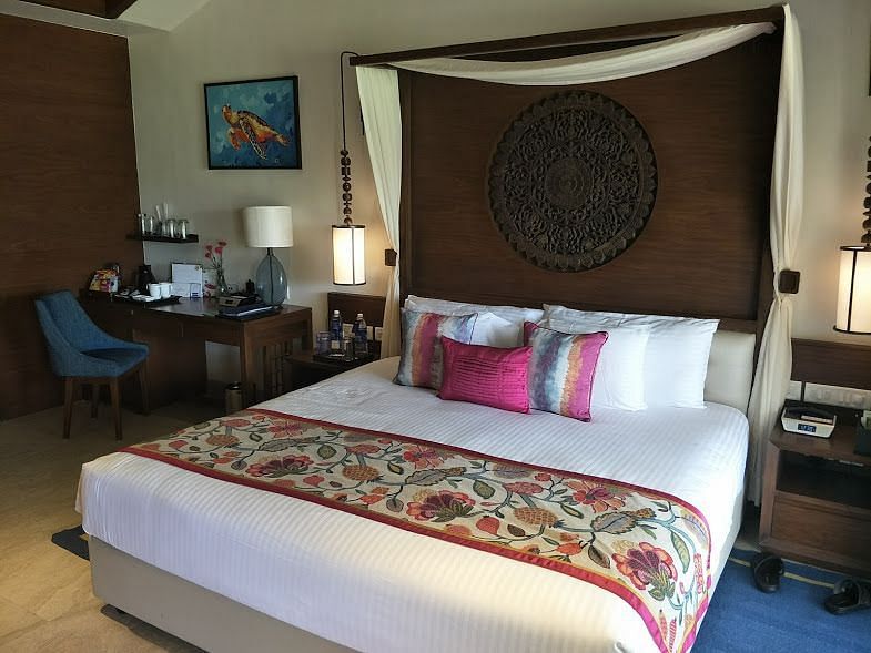 A bedroom featuring a wooden-patterned headboard with a working desk and chair.