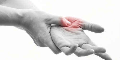 A hand positioned with fingers extended, with a marked area by the thumb of the other hand