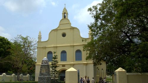 The Tower House - St Francis Church in Kochi captured with people walking in and out of the church