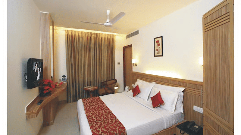 A room with double beds, pillows, sheets, and switch board.