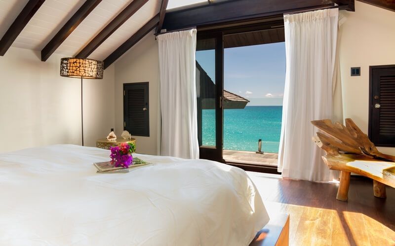 Luxury beachfront room with ocean view and elegant decor.