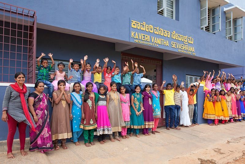 Group of people in colorful clothing standing outside a building, outdoor setting - Shreyas Retreat