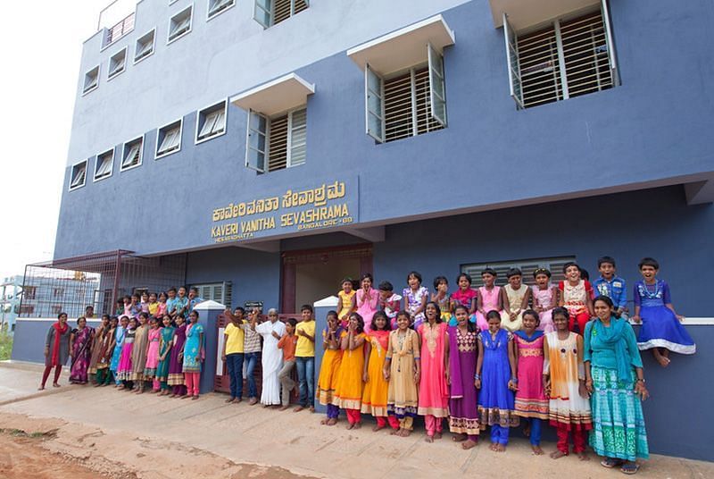 Group of people in colorful clothing standing outside a building, outdoor setting - Shreyas Retreat