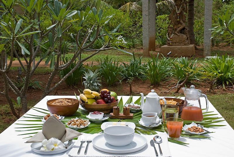 A table filled with fresh, nutritious Ayurvedic food in a lush green environment - Shreyas Retreat