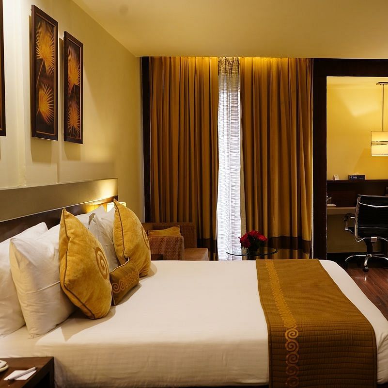 Club Room decked with a comfy bed, a television and a work desk at Shervani Nehru Place, New Delhi