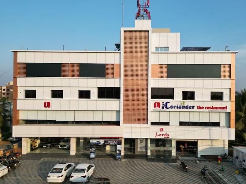 The image shows a multi-story building with signage indicating Coriander the restaurant and Lords at the entrance - Lords Eco Inn Navsari.