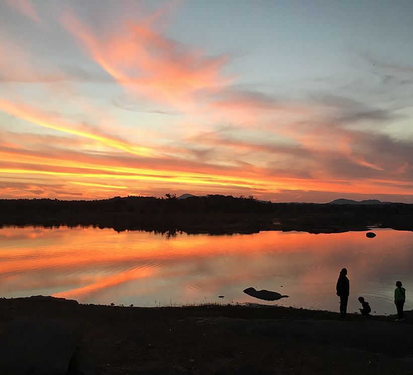 image of people along side the lake and soaking in the Sunset at dev shree, deogarh