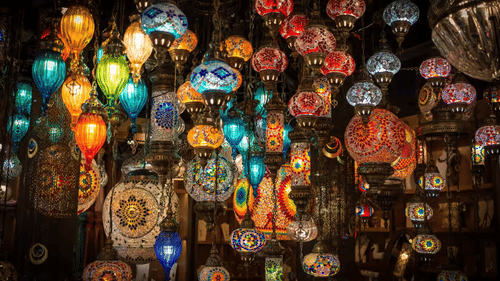 A collection of colorful hanging lanterns in various shapes and patterns displayed together.