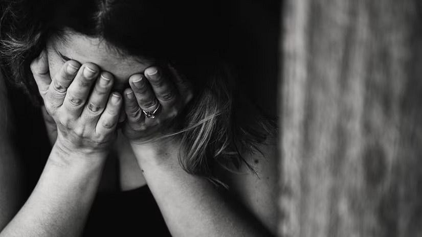 A woman covering her face with her hands, symbolizing stress or anxiety.