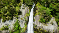 waterfall in the mountains with small trees 
