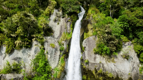 waterfall in the mountains with small trees 