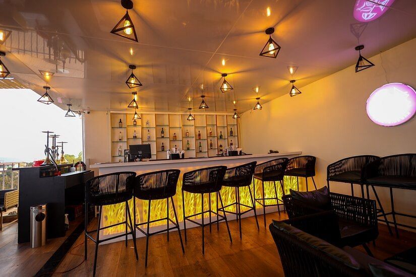 Image if a dining space with chairs lined in front of the counter table  at Vagator Downtown, Goa